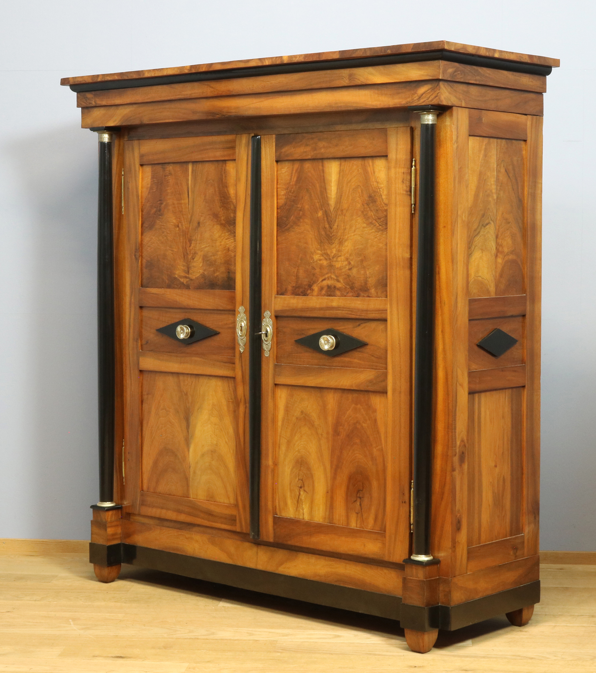 Nussbaum Biedermeierschrank mit Vollsäulen und ebonisierten Zierelementen, restauriert und mit Schellack poliert, süddeutsch um 1820